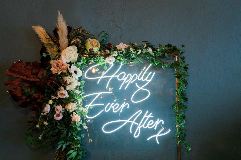 a neon sign with some floral décor | Wedifys