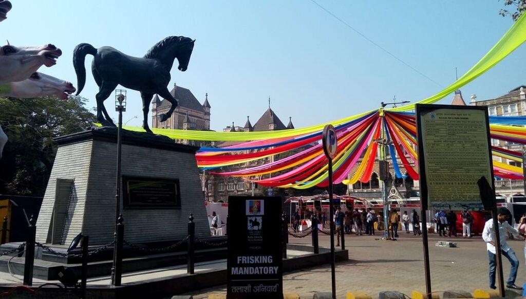 a black horse as a decoration piece on top in front of the Kala Ghoda festival | Wedifys