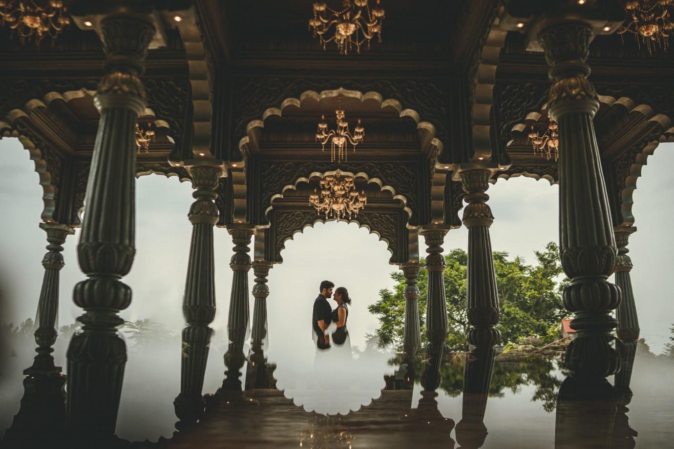 a couple standing in between a temple at the White Mist Resort for a wedding photoshoot | Wedifys