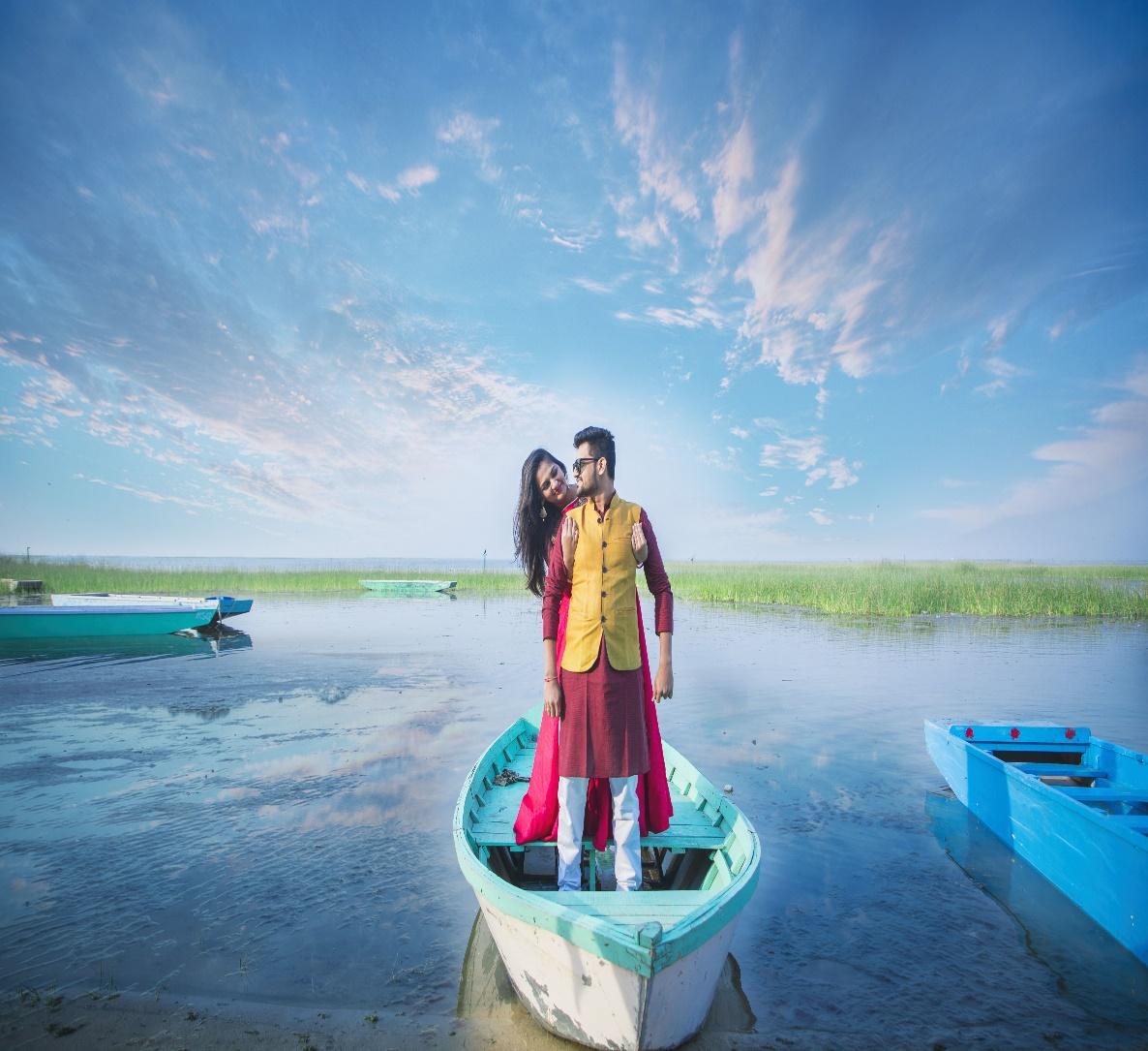 a couple standing on a boat for their pre-wedding photoshoot in the Nalsorovar Lake | Wedifys