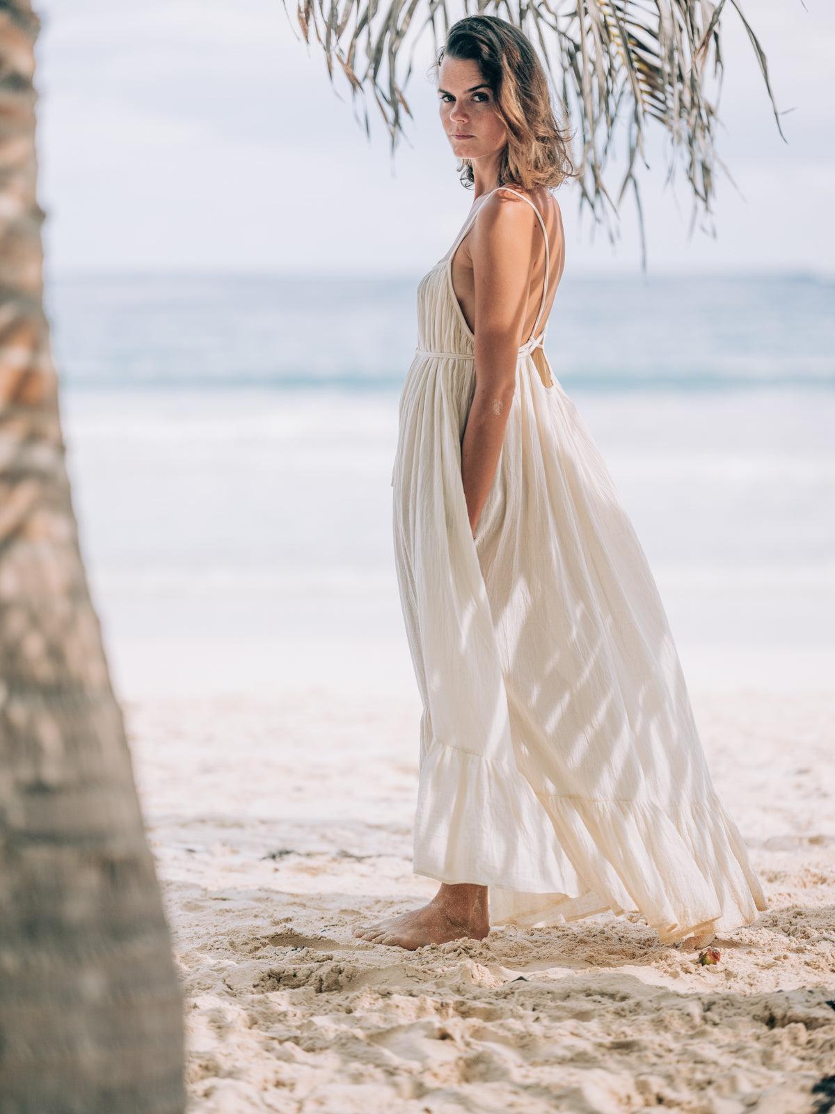 a woman wearing a beach style flowy dress | Wedifys
