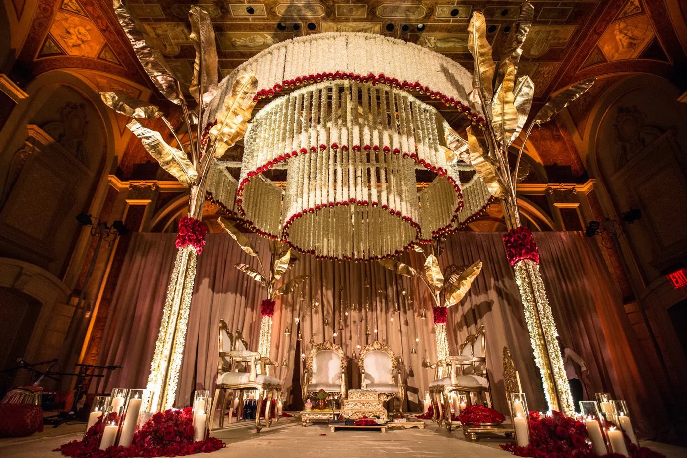 traditional style mandap with hundreds of ivory flowers dipped in red roses | Wedifys