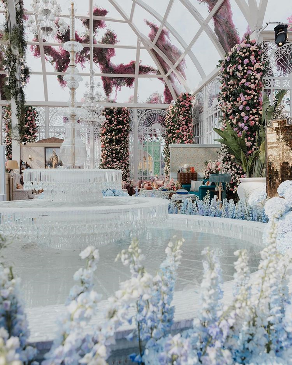 The complex's fountain area is decorated with pink, white and blue flowers.  | Anant Ambani and Radhika Merchant Pre-Wedding Decor | Wedifys