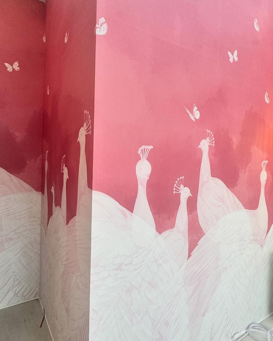 Another focal point is these pink walls featuring white peacocks and butterflies.  | Anant Ambani and Radhika Merchant Pre-Wedding Decor | Wedifys