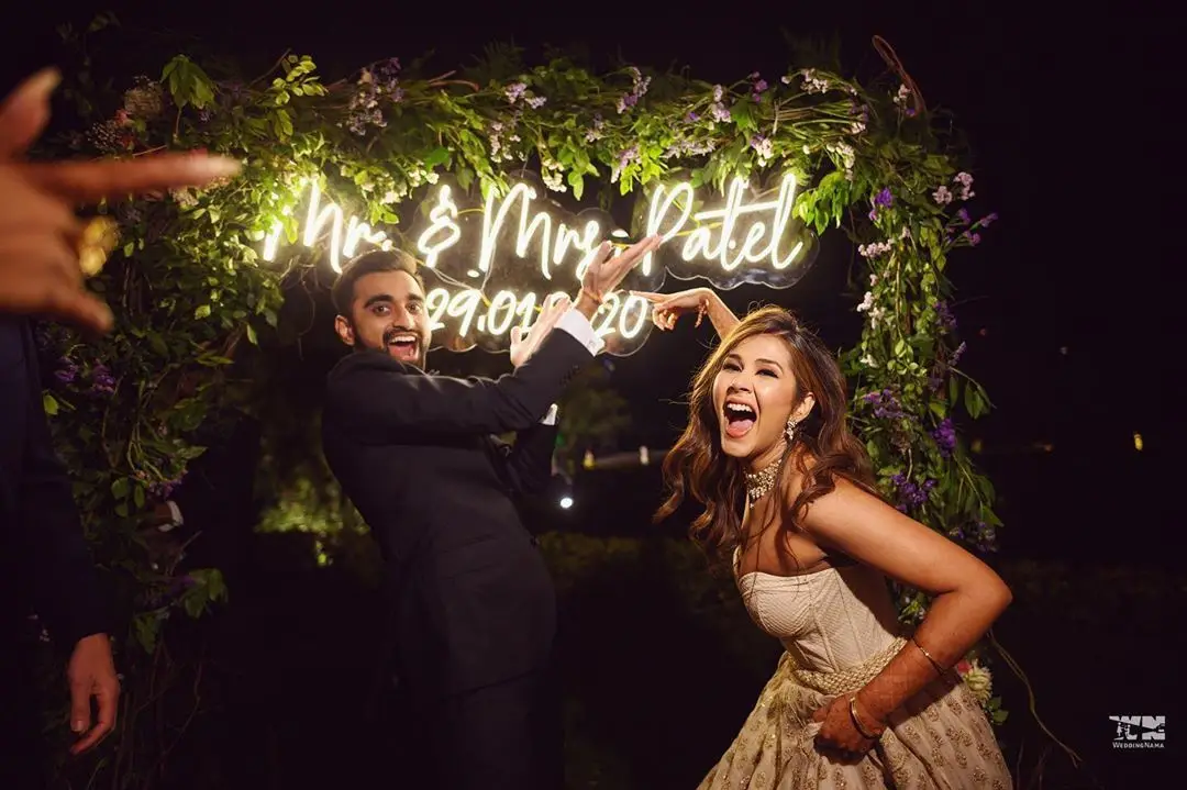 couple posing in front of the wedding hashtag | Wedifys