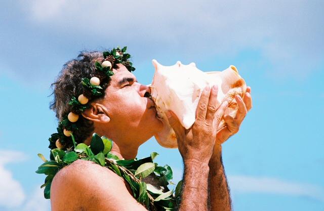 a man blowing in a Hawaiian Conch Shell announcing about a wedding called Blowing of the Pū | Wedifys
