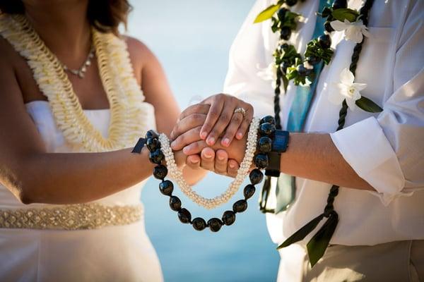 hands of a couple tied with traditional Koa wood, a culture of Hawaii | Wedifys