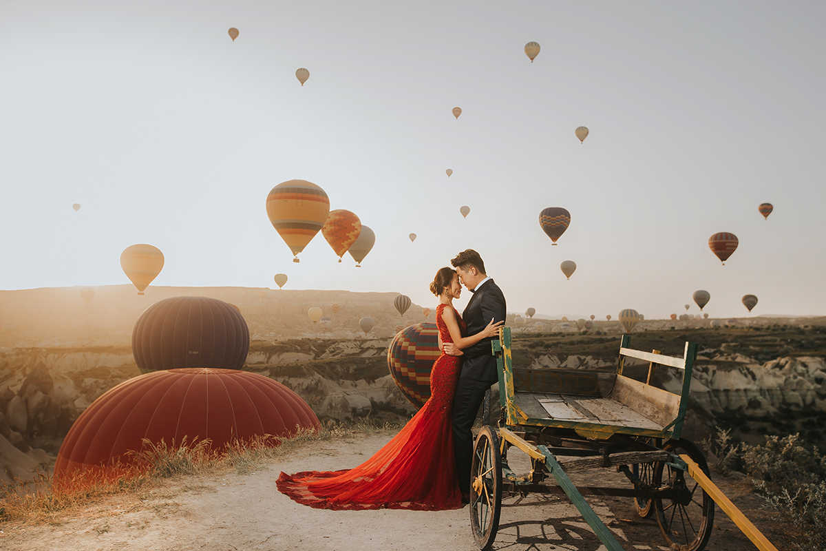a couple in their pre-wedding photoshoot with the hot-air balloons in the background | Wedifys