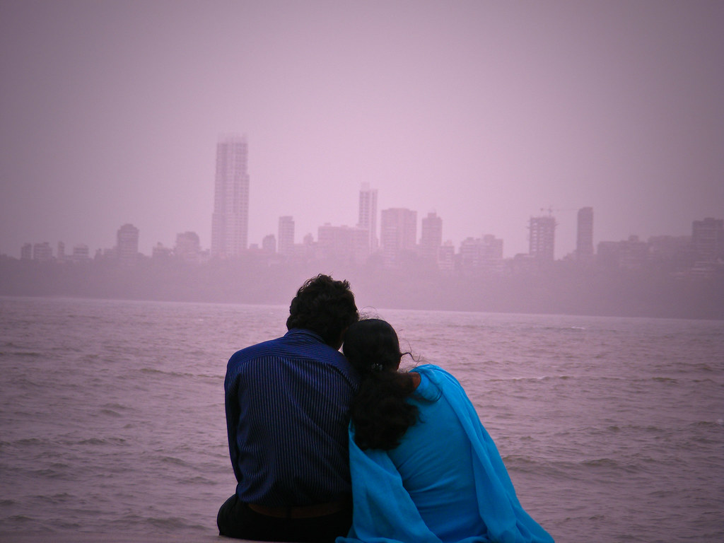 a couple sitting at the Marine Drive facing towards the Arabian Sea | Wedifys